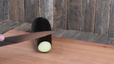 Adam patlıcan kesiyor. Yan görüş. 4K UHD video görüntüsü 3840X2160.