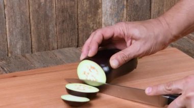 Adam patlıcan kesiyor. Yan görüş. 4K UHD video görüntüsü 3840X2160.