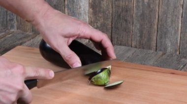 Adam patlıcan kesiyor. Yan görüş. 4K UHD video görüntüsü 3840X2160.