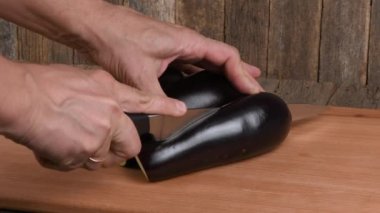 Adam patlıcan kesiyor. Yan görüş. 4K UHD video görüntüsü 3840X2160.