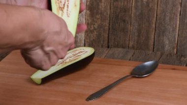 Adam patlıcanı soyuyor. Tekneyle patlıcan tabağı pişirmek. Yan görüş. 4K UHD video görüntüsü 3840X2160.