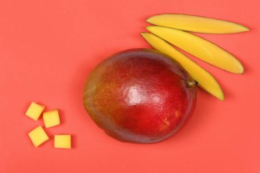 Kırmızı arkaplanda taze mango meyveleri var. Yüksek çözünürlüklü. Tam alan derinliği.