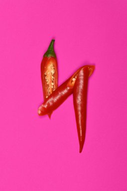 Kırmızı biber pembe arka planda izole edilmiş. Yüksek çözünürlüklü. Tam alan derinliği.