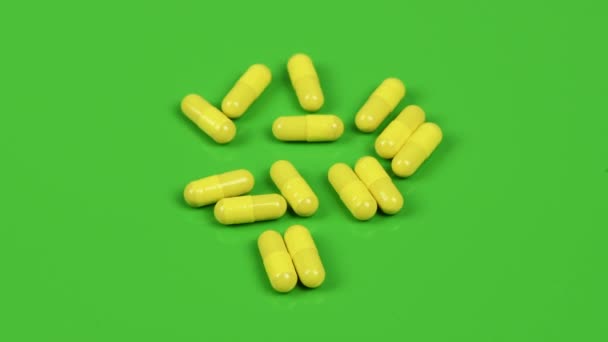 Yellow Capsules Green Background Side View Loop Motion Rotation 360 — 图库视频影像