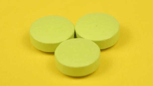 Πράσινα Χάπια Κίτρινο Φόντο Πλευρική Άποψη Κίνηση Βρόχου Περιστροφή 360 — Αρχείο Βίντεο