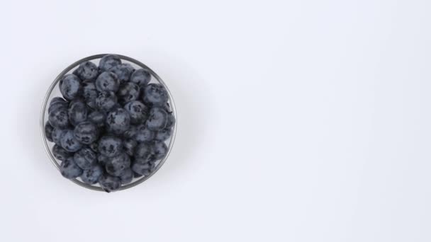 Blaubeeren Einer Glasschüssel Auf Weißem Hintergrund Ansicht Von Oben Schleifenbewegung — Stockvideo