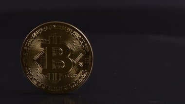Altın Bitcoin sembolü, şifreli para olarak yuvarlak para, siyaha dijital para. Yan görüş. 4K UHD video görüntüsü 3840X2160.