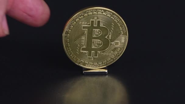 Ett Finger Vänder Ett Bitcoin Mynt Tillbaka Sidovy Uhd Videofilmer — Stockvideo