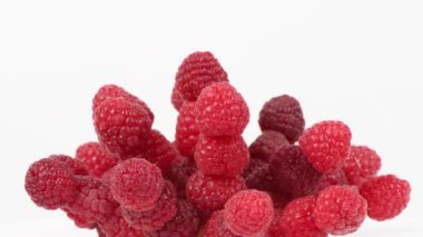 Beyaz üzerine ahududu. Aşırı derecede yakın çekim. Yan görüş. Döngü hareketi. Rotasyon 360. 4K UHD video görüntüsü 3840X2160.