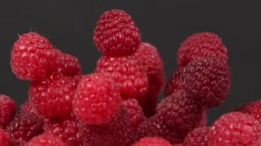 Siyah üzerine ahududu. Aşırı derecede yakın çekim. Yan görüş. Döngü hareketi. Rotasyon 360. 4K UHD video görüntüsü 3840X2160.