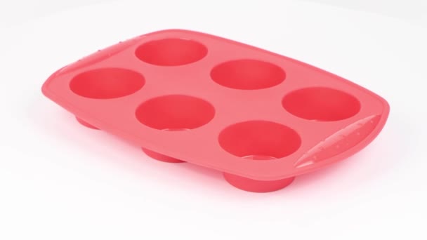 白い背景にマフィンとカップケーキを調理するための赤いシリコーンフォーム サイドビュー ループ モーション 360回転 Uhdビデオ映像3840X2160 — ストック動画