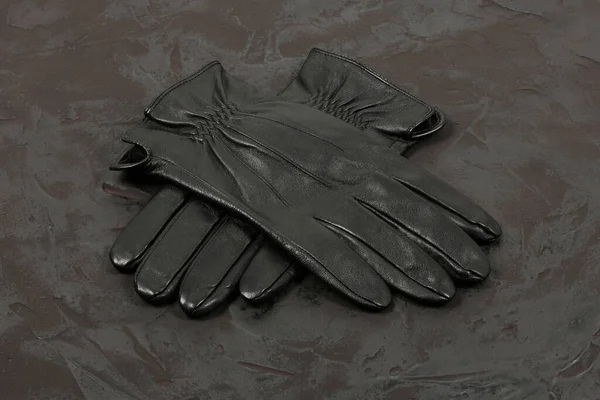 Casual leather gloves isolated on black background. Pair of gloves folded crosswise. High resolution photo. Full depth of field.