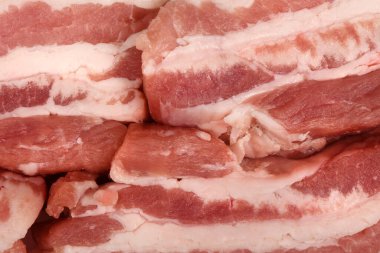 Küçük dilimlenmiş taze domuz eti. Çiğ pastırma arka planı. Yüksek çözünürlüklü. Tam alan derinliği.