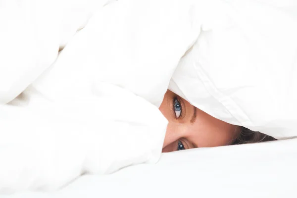 Jovem mulher na cama sob cobertor — Fotografia de Stock