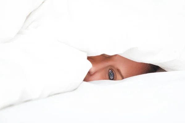 Young woman in bed under blanket — Stock Photo, Image