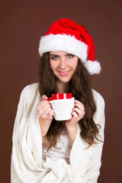 Woman in red Christmas hat with a cup of tea — Stock Photo, Image