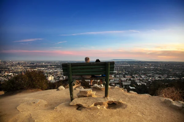Los şehir manzaralı bir bankta oturan iki angele Stok Fotoğraf