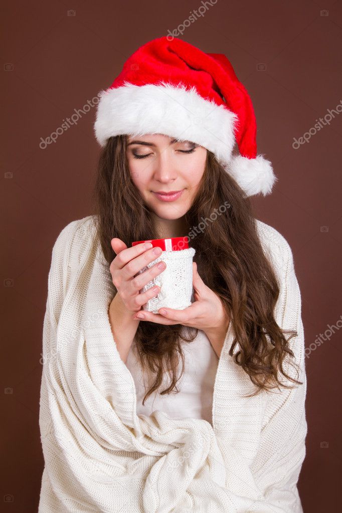 Woman in red Christmas hat with a cup of tea