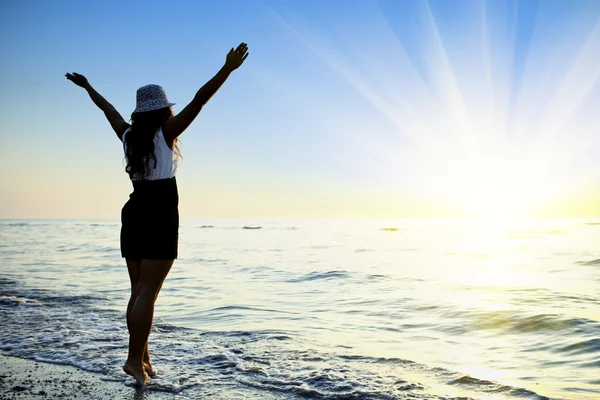 mutlu bir kadın deniz günbatımı atlama