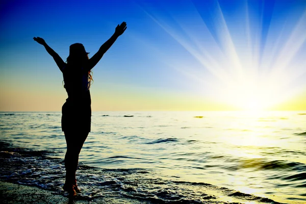 Donna felice che salta nel tramonto del mare — Foto Stock
