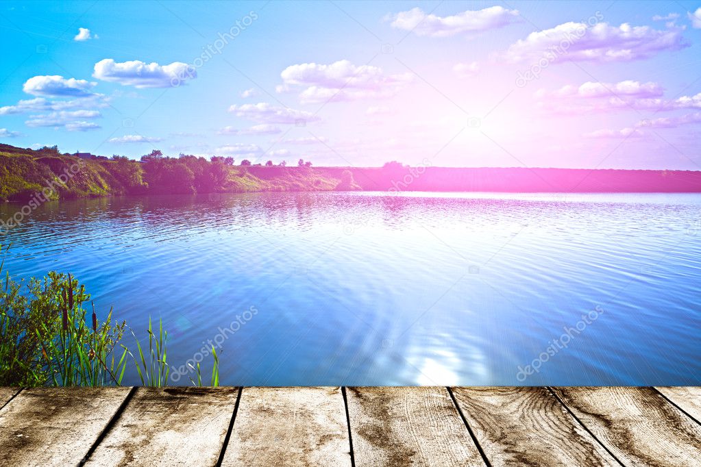 Sunset on forest lake and wooden board background