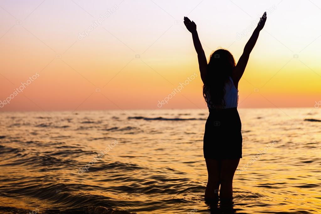 Happy Woman Jumping in Sea Sunset
