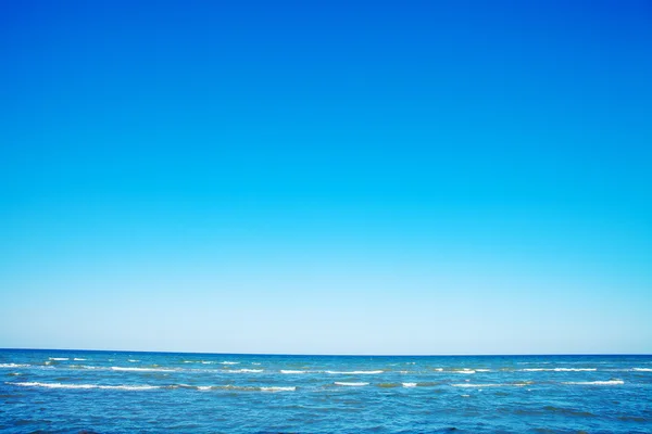 Морской пейзаж с чайкой в голубом небе — стоковое фото