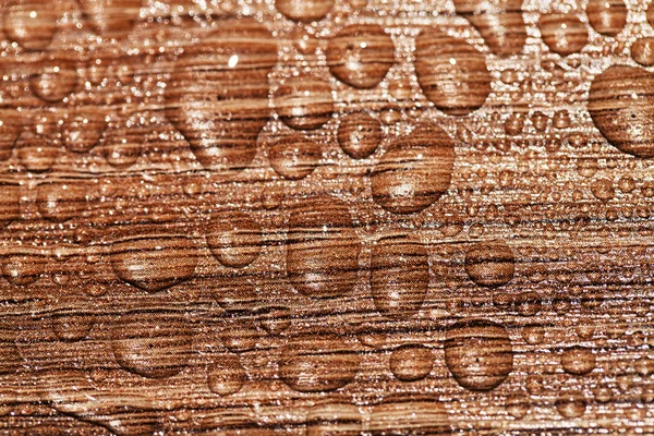 Gotas de agua en una superficie de madera — Foto de Stock