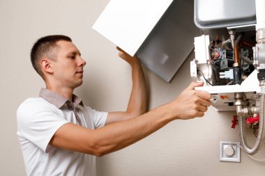 Tesisatçı, Isıtma Cihazları sorununu çözmeye çalışıyor. Gaz kazanının tamiri