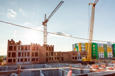 Yeni binaların arka planında vinçler olan inşaat alanı