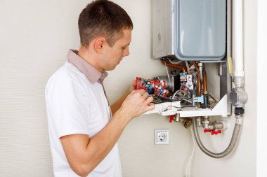 Tesisatçı, Isıtma Cihazları sorununu çözmeye çalışıyor. Gaz kazanının tamiri