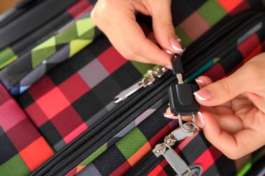 Kadınların elleri bir bavulu eşyalarla açar. seyahat kavramı