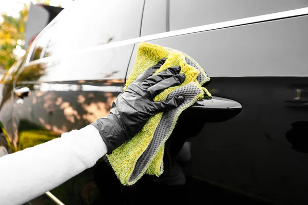 여자들은 자동차를 닦고 , 마이크 로 섬유 천 을 사용하고, 구두약을 사용하여 자동차의 몸체를 윤으로 닦는다. — 스톡 사진