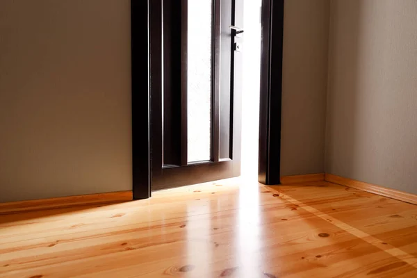 Het licht dat door de half open deur van het huis schijnt — Stockfoto