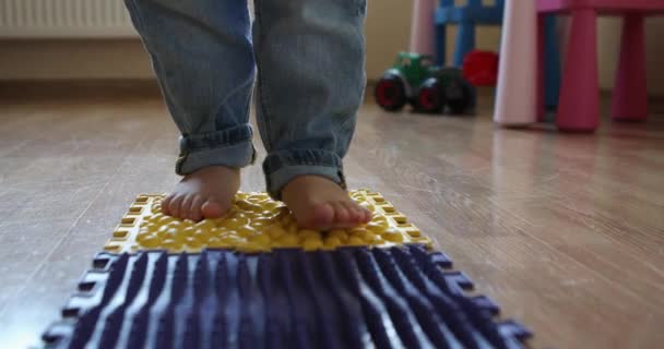 Alfombra de masaje de pies de bebé niño pequeño. — Vídeo de stock