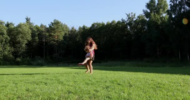 Glückliche Familien spielen bei Sonnenuntergang mit Kindern im Park. — Stockvideo