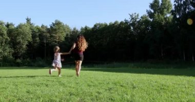 Mutlu aile gün batımında çocuklarla parkta oynanır..