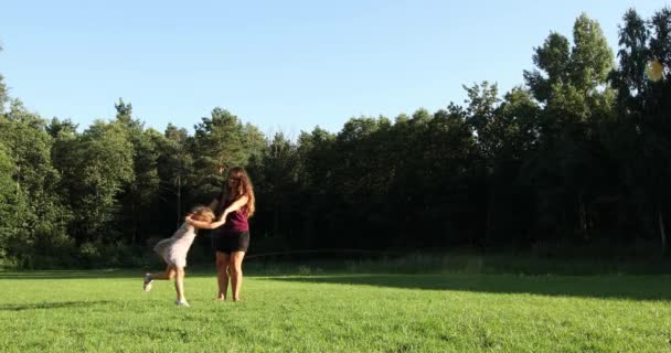 Ευτυχισμένη οικογένεια παίζουν με τα παιδιά στο πάρκο στο ηλιοβασίλεμα. — Αρχείο Βίντεο