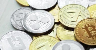 Ahşap zemin üzerinde bitcoin, dalgalanma ve ethereum sembolü.
