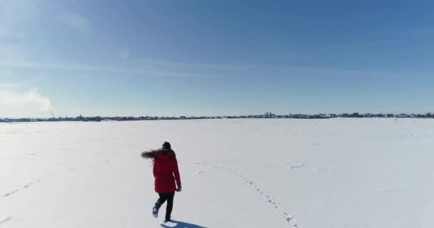 Flicka som springer på ett snöfält — Stockvideo