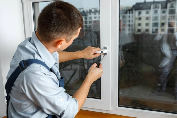 El trabajador instala y comprueba la ventana en la casa — Foto de Stock