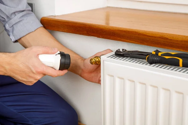 Επισκευή καλοριφέρ θέρμανσης κοντά. άνθρωπος επισκευή καλοριφέρ με κλειδί. Αφαίρεση αέρα από το ψυγείο — Φωτογραφία Αρχείου