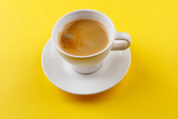 Schwarzer Kaffee in einer Tasse auf gelbem Hintergrund — Stockfoto