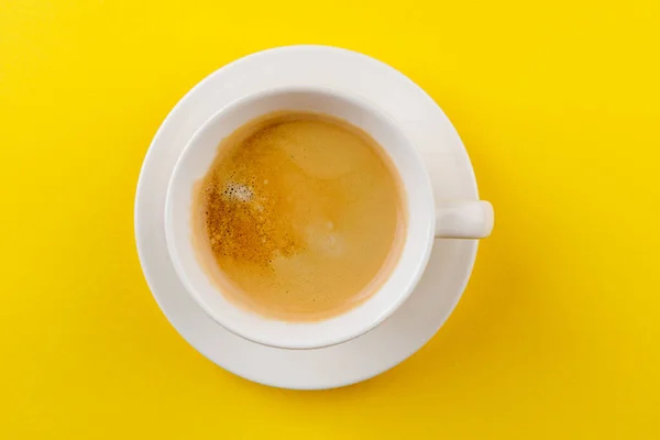 노란 배경의 컵 안에 있는 검은 커피 — 스톡 사진