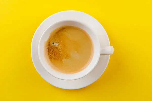 Café negro en una taza sobre un fondo amarillo — Foto de Stock