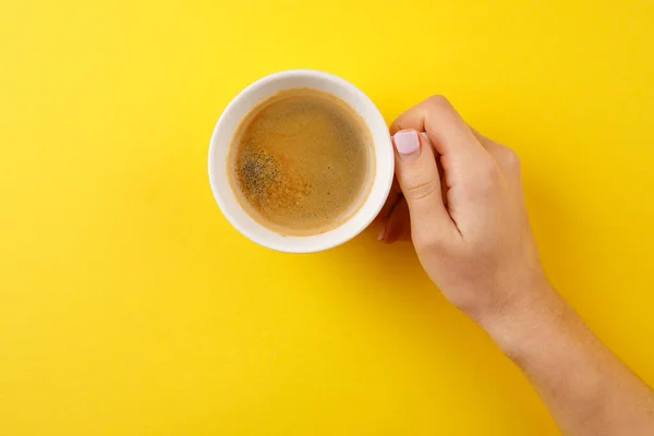 Schwarzer Kaffee in einer Tasse auf gelbem Hintergrund — Stockfoto
