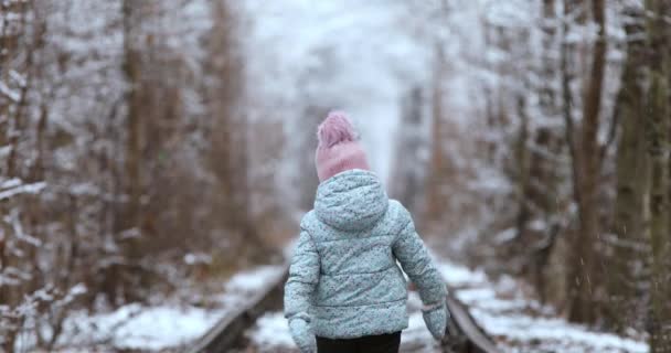 Dívka kráčí po kolejích v zimě — Stock video