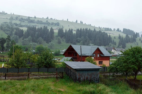 Huis op een steile berghelling in de karpaten tussen het groene bos — Stockfoto