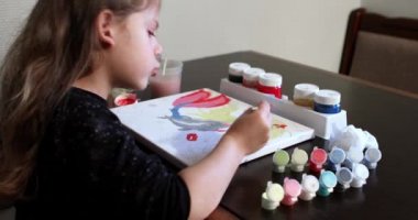 Kız bir resim kağıt üzerinde çizer. 
