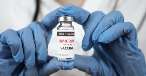 Covid 19 OMICRON วัคซีนตัวแปรในมือบนพื้นหลังสีขาว — วีดีโอสต็อก